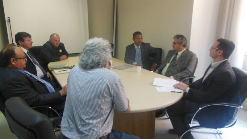 sete homens reunidos em torno de uma mesa