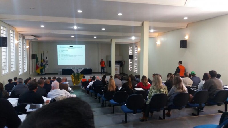 Auditório com muitas pessoas assistindo a uma palestra
