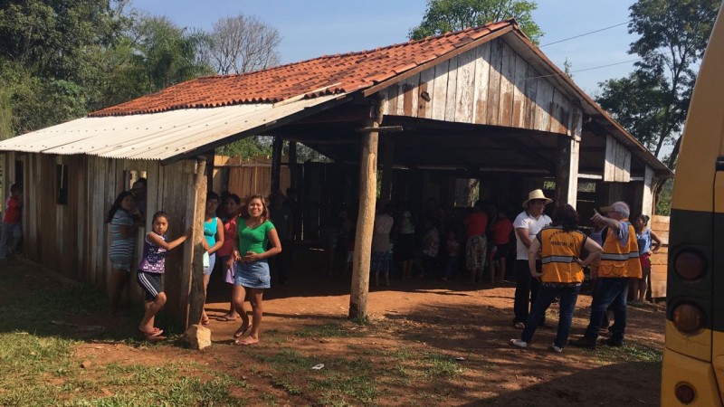 Galpão indígena. Muitas pessoas. Ambiente rural.
