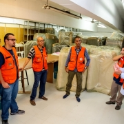 Grupo de pessoas reunidas olhando os sofás doados.