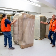 Dois homens vestem laranja em frente deles um sofa branco