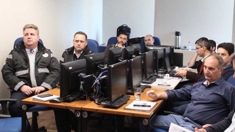 Pessoas sentadas em mesas com computadores