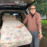 Luis Carlos Roveda posa ao lado de seu carro com dois colchões para doar às vítimas do ciclone