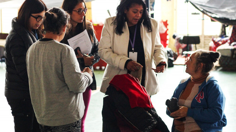 A foto mostra voluntários conversando com os abrigados