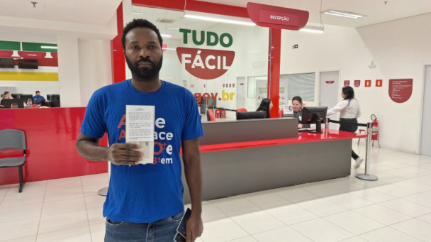 A foto mostra Marckenson Pierre Charles, nascido no Haiti, recebendo o benefício
