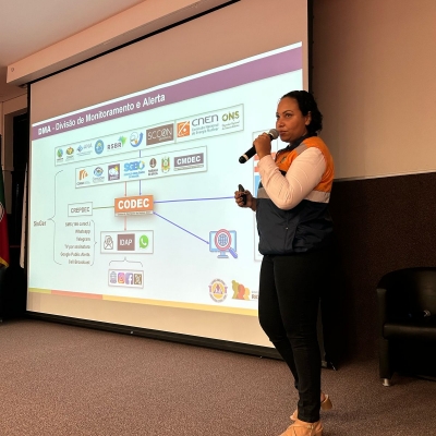 Representante da Defesa Civil Estadual utiliza recurso digital para apresentar o conteúdo à plateia