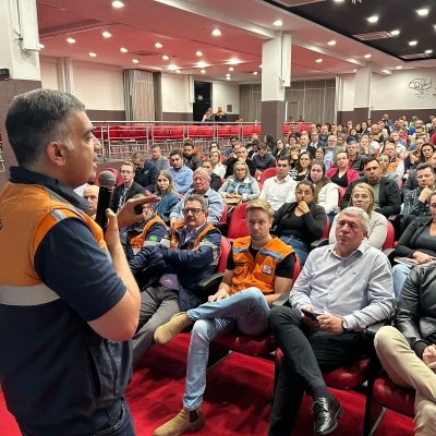Representante da Defesa Civil Estadual palestra para pessoas reunidas em um auditório