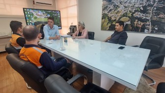 mesa de reunião com 4 homens e 1 mulher 