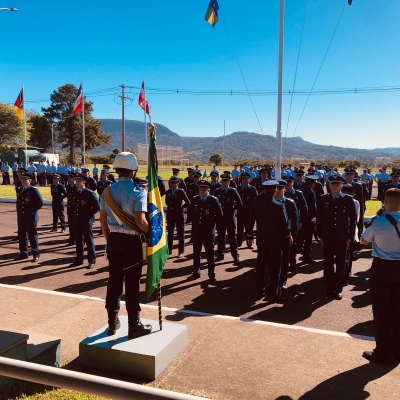Homens alinhados com bandeira a frente 