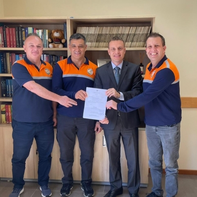 Quatro homens posando para foto segurando documento 