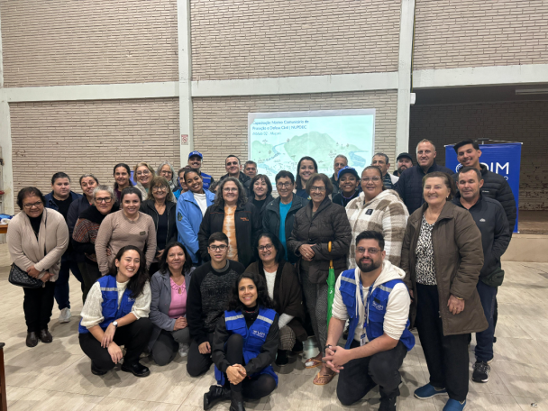 Grupo de cerca de 40 pessoas posa para foto